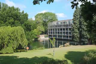 An image of a pond outside some apartments at Alderley Park