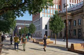 A photo of people walking through the MMU campus outside All Saints Park