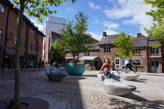 Low shot of Goose Green showing children playing on the feature seating.