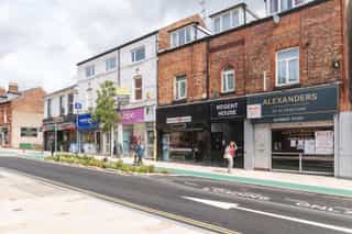 New cycle lanes and SuDS outside some shops on an Altrinhcam street.