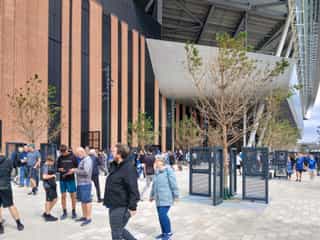 Fans walk by the newly planted trees in the fan plaza