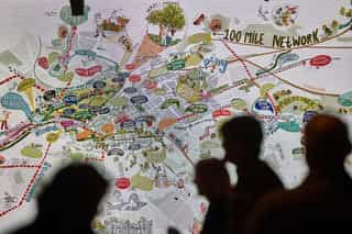 A hand drawn sketch of Manchester on a big screen, through a crowd of people