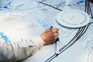 Image showing a person taking part in a creative engagement session, writing their thoughts on a selection of post it notes.