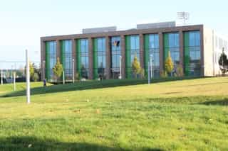 An image of a Sixth Form College, a man walks towards it in the distance