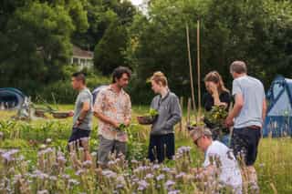 An image of people foraging for vegetables, collecting them in baskets