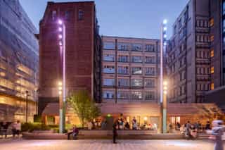 Dusk shot of The Pilcrow in Sadler's Yard with people sat outside enjoyign a drink.