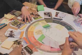 Planit's Regenerative Design Tool being used at a workshop across a table.