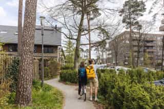 An image of a man pointing to something in the distance to a woman on a bike