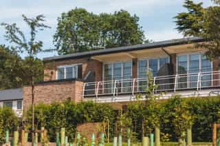 An image of the developed Standish House with a view of the young planting growing on site