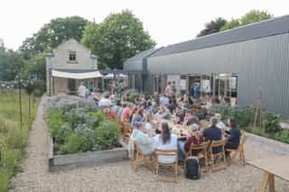 An image of the Planit team sitting down for dinner outside the Gloucestershire studio