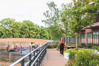 An image of a woman walking along a canal at Sugar House Island
