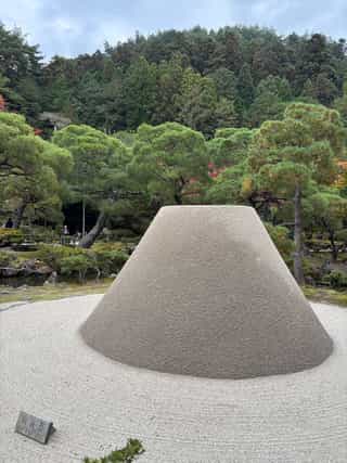 A neatly collected pile of weathered stones to form a flat topped cone structure, to symbolise the beauty of impermanence.